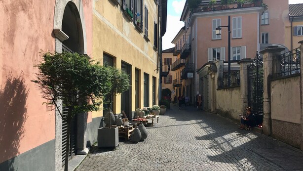 A cobblestone street lined with buildings, some with balconies and windows.