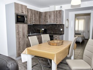 Enjoy a compact kitchen and dining area with microwave and range hood, perfect for cooking and socializing.