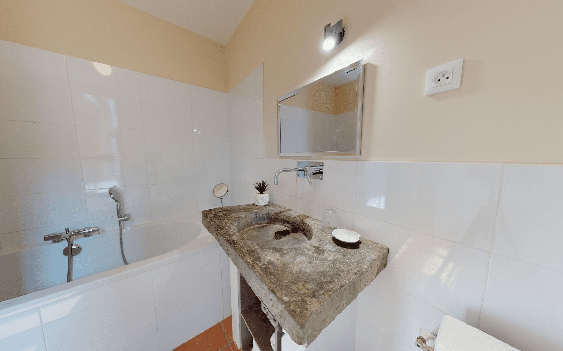 Un bagno con una vasca, un lavandino con specchio e un water.