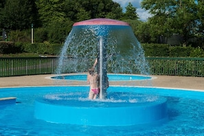 Una piscina al aire libre, sombrillas, tumbonas