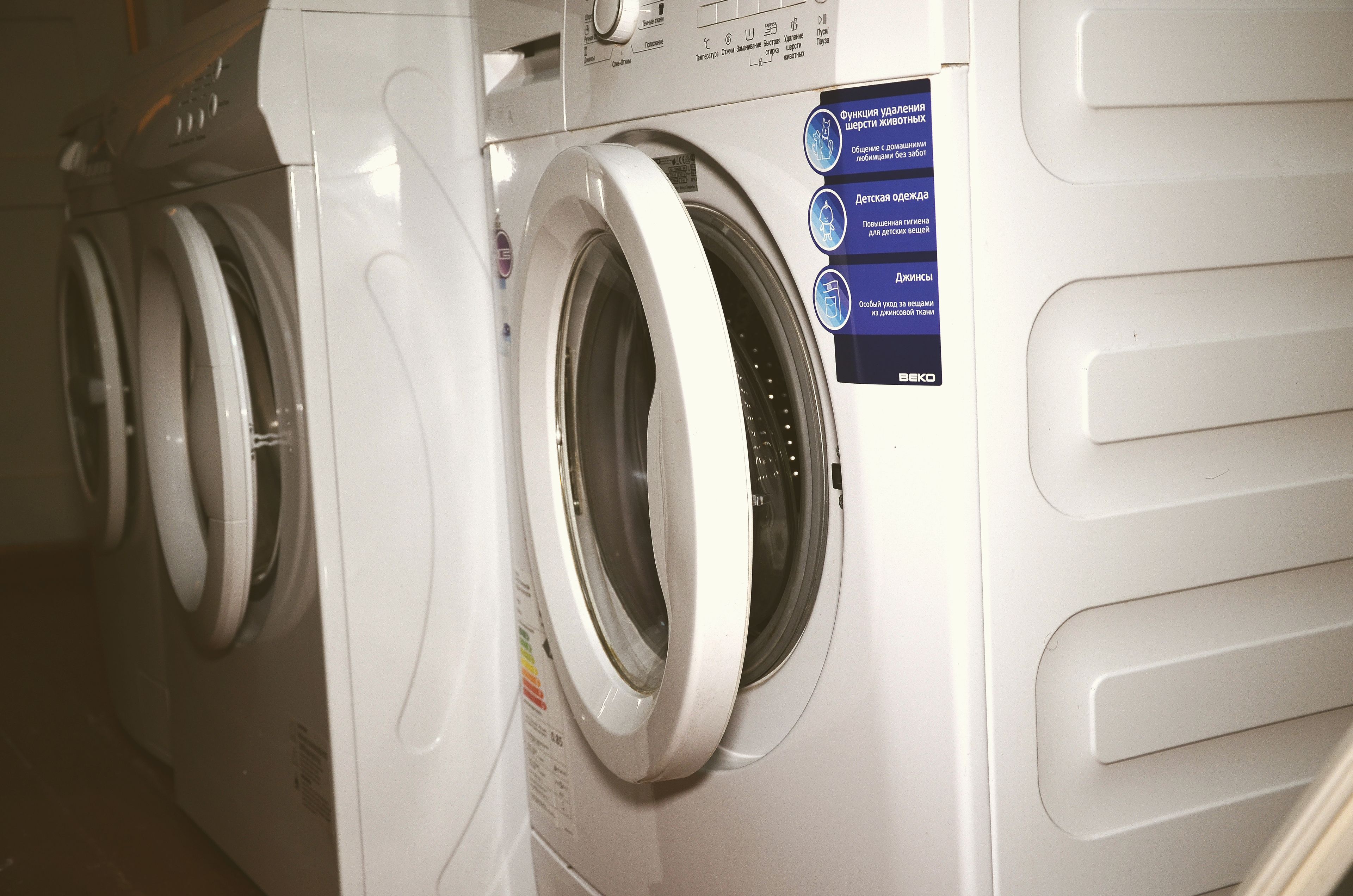 Varias lavadoras blancas con panel de control y una etiqueta de mantenimiento.
