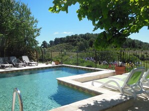 Una piscina al aire libre de temporada, sombrillas