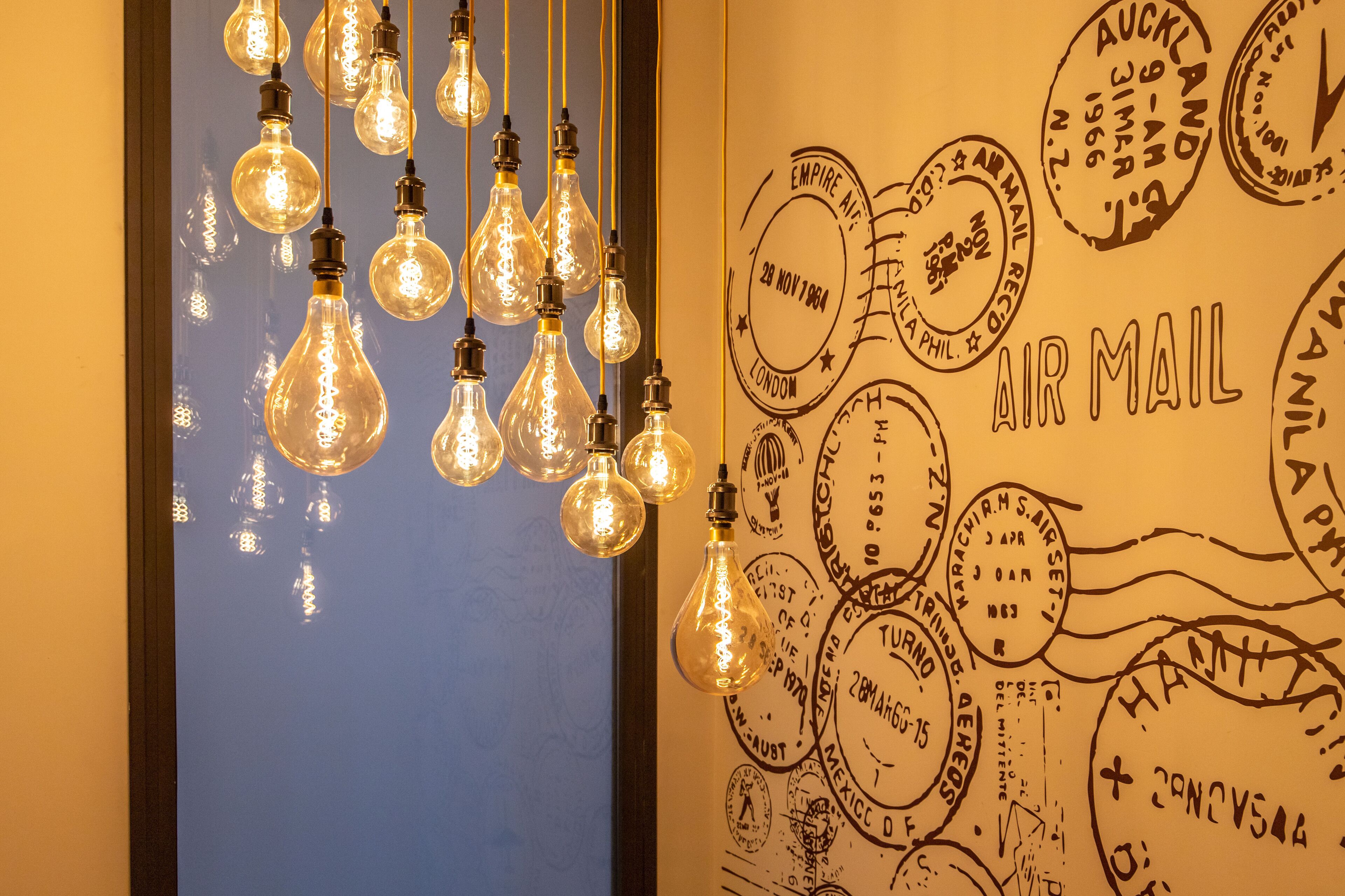 Un mur orné de guirlandes lumineuses et de timbres de courrier aérien.