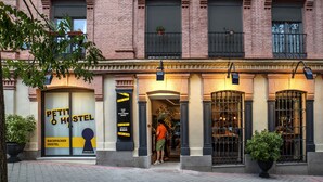 Un edificio de ladrillo con un letrero que dice 'Petit Hostel' y una puerta.