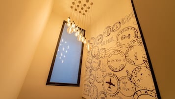 Una pared con una colección de sellos antiguos y un colgador de luz.
