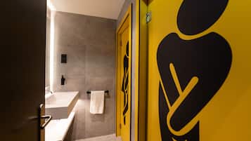 Un bany modern amb un mirall gran, un lavabo i una tovallola penjada a la paret.