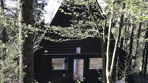 A cabin with a dark exterior, two windows, a door, and a small porch area. - Orava Durbuy (Durbuy)