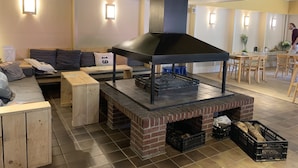 A cozy living area with a fireplace, seating, and a dining area. - Orava Durbuy (Durbuy)