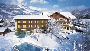 Un hotel grande con varias construcciones, piscina y paisajes nevados.