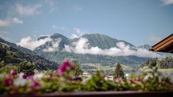 Eine Berglandschaft mit Blick auf ein Tal und einem Haus im Vordergrund.