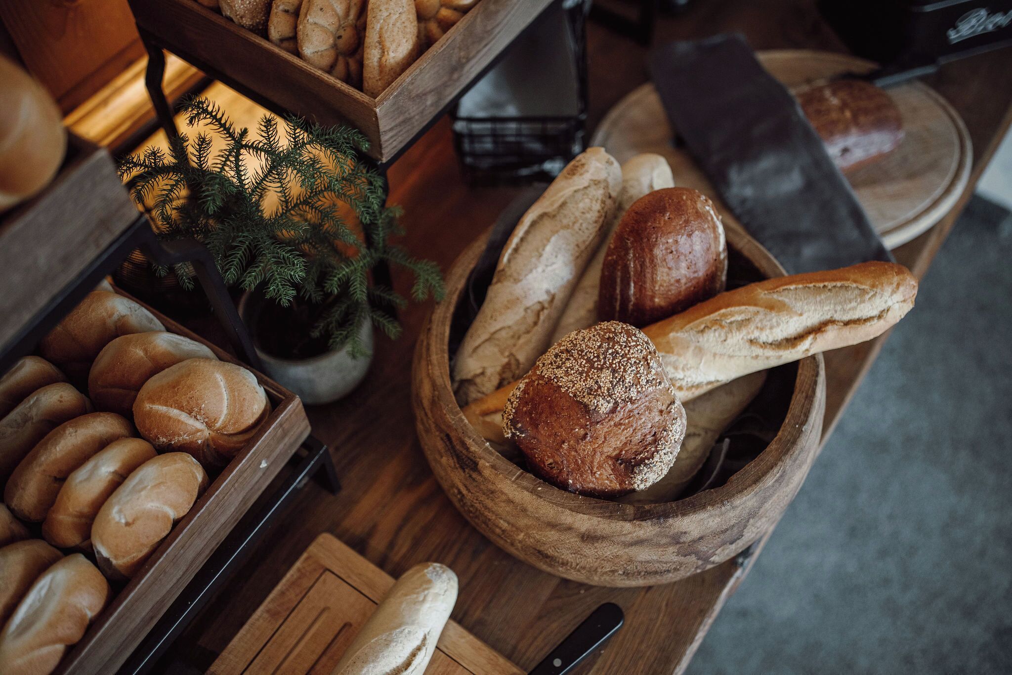 A variety of breads in wooden containers on a table.