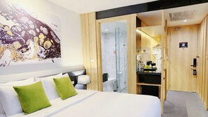 A hotel room with a large bed, a glass shower enclosure, a wooden wardrobe, and a small kitchenette. - Zazz Urban Ho Chi Minh Hotel (Ho Chi Minh City)