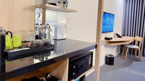 A modern kitchen with a black countertop, a coffee machine, and glass jars. - Zazz Urban Ho Chi Minh Hotel (Ho Chi Minh City)