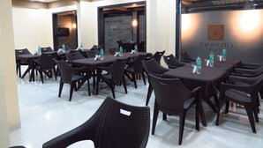 A conference room with multiple tables and chairs, equipped with water bottles and notepads. - City Palace Resort (Mawal)