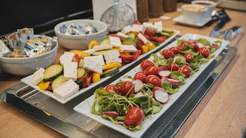 Ein reichhaltiges Buffet mit verschiedenen Speisen, darunter Salate, Käse und Gemüse.