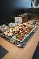Una mesa de buffet con diversos platos, como ensaladas, quesos y verduras.