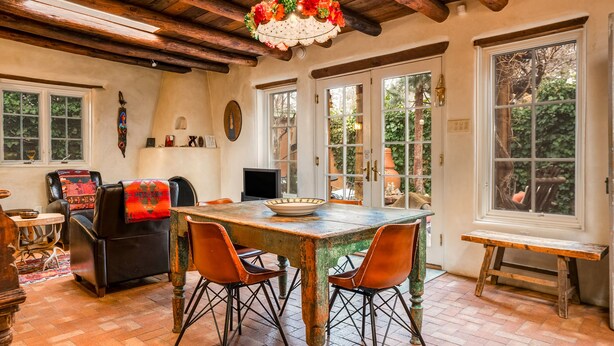 A rustic dining area with a wooden table, four chairs, and a decorative hanging light fixture. - Authentic Santa Fe Home-Step into History & Charm (Santa Fe)