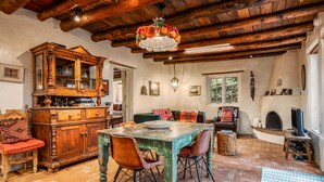 A rustic dining area with a wooden table, chairs, and a chandelier. - Authentic Santa Fe Home-Step into History & Charm (Santa Fe)