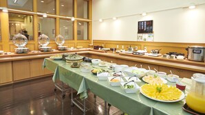 Una barra de buffet con diferentes alimentos y un dispensador de zumo.