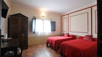 A room with two beds, a desk, and a wardrobe.