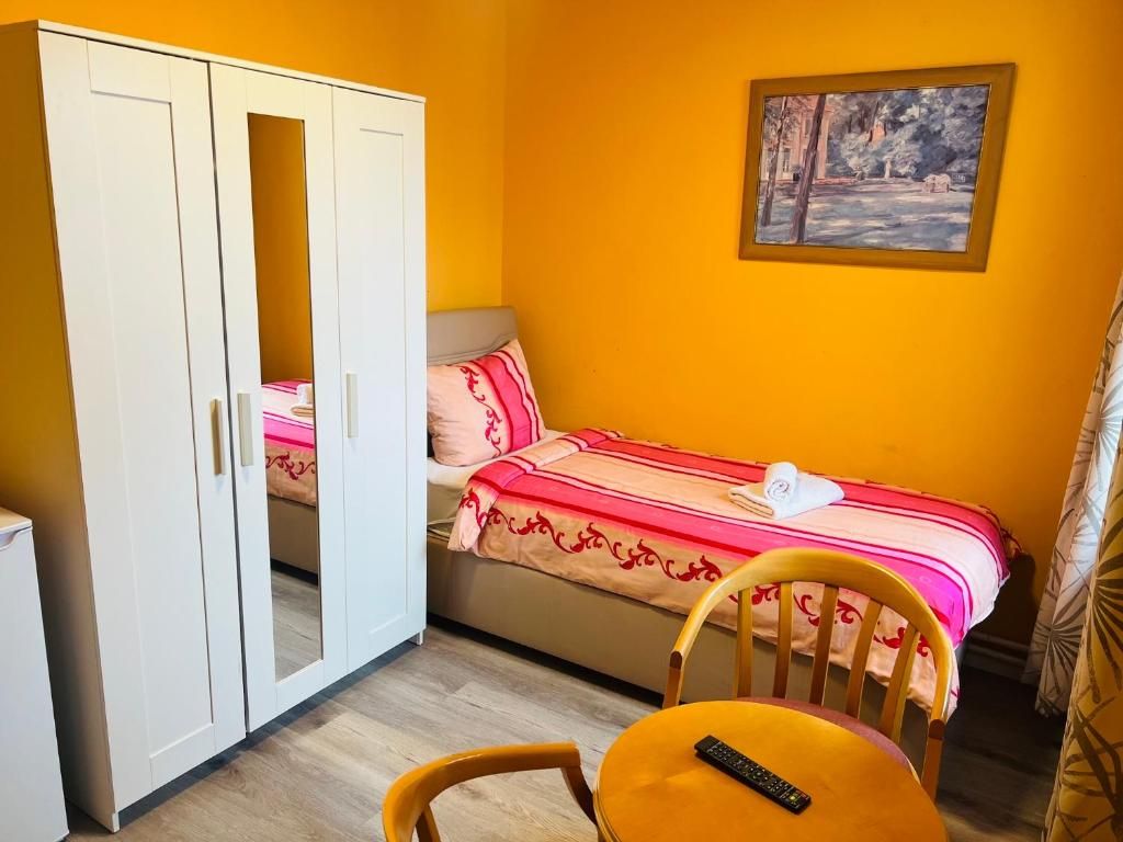 Quarto com cama, guarda-roupa, uma cadeira e um quadro na parede.