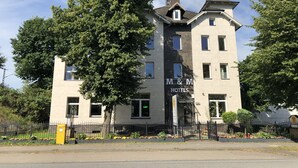 Un edificio a due piani con un cartello che riporta la scritta "M & M HOTELS".