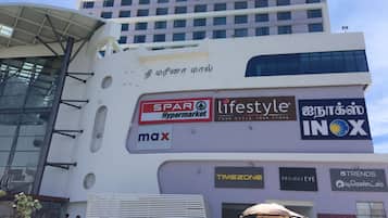 Un edificio de varios pisos con diversos rótulos comerciales, incluyendo 'SPAR Hypermarket', 'lifestyle', 'max', 'INOX', 'TIMEZONE', 'PROJECT EVE' y 'RE-GEN-TA'.