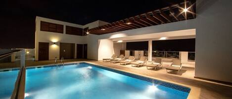 Una piscina al aire libre, tumbonas