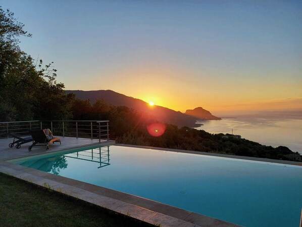A swimming pool with a view of the sunset over the sea, a lounge chair, and a railing. - "Villa Roverelle" Villa with Pool - CIN IT082027C2IYJ8SZW9 CIR 19082027C206967 (Cefalù)