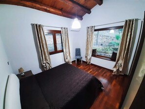 A bedroom with a bed, a chair, and a window with curtains. - "Villa Roverelle" Villa with Pool - CIN IT082027C2IYJ8SZW9 CIR 19082027C206967 (Cefalù)