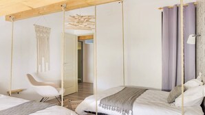 A room with two beds, a hanging chair, and macrame wall decor. - Loft Nature Bien-être Piscine Chauffée Privée Tarn (Peyrole)