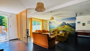 Una sala de estar moderna con un juego de sofá, una mesa de comedor y un ventanal con vistas a zonas verdes.