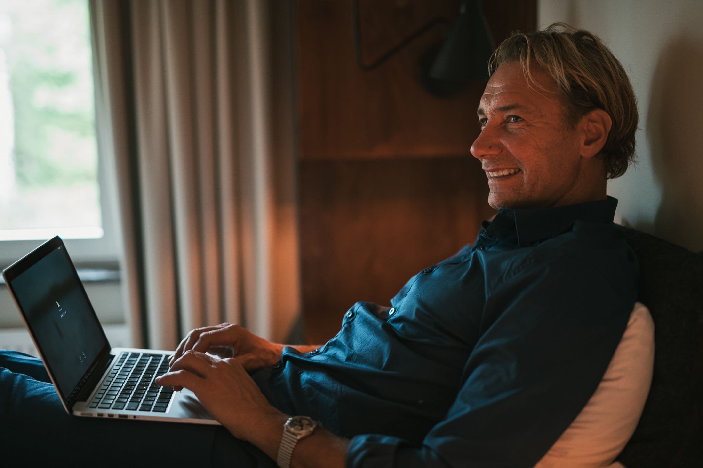 A person sitting on a couch using a laptop.