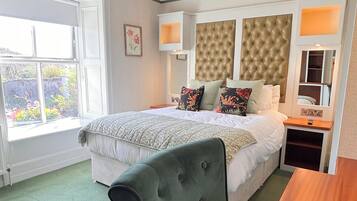 Una camera d'albergo con un letto, una scrivania, una sedia, una finestra e una lampada a soffitto.