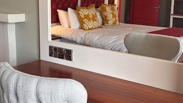 Un dormitorio con una cama, un escritorio y una silla. Hay un espejo en la pared.