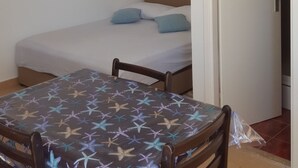 A room with a bed, a table, and a wall clock. - Studio apartment GIRO (Omis)