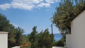 A balcony with potted plants and a view of the sea. - Studio apartment GIRO (Omis)