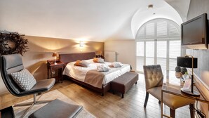 A modern hotel room with a large bed, a desk, a chair, and a television. - B&B Bertem Natuur (Bertem)