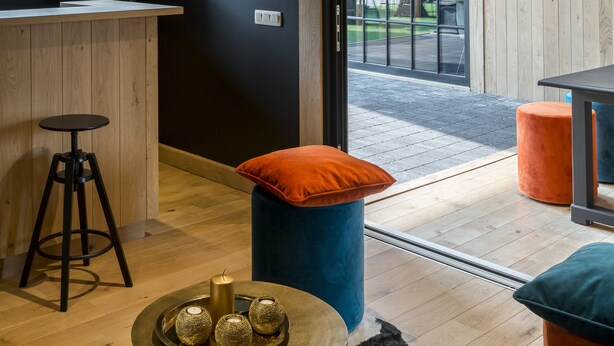 A modern interior with a wooden ceiling, a bar area, and a view through a glass door to the outside. - B&B Bertem Natuur (Bertem)
