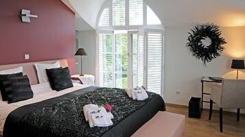 Un dormitorio con una cama grande, un banco, un escritorio y una silla.