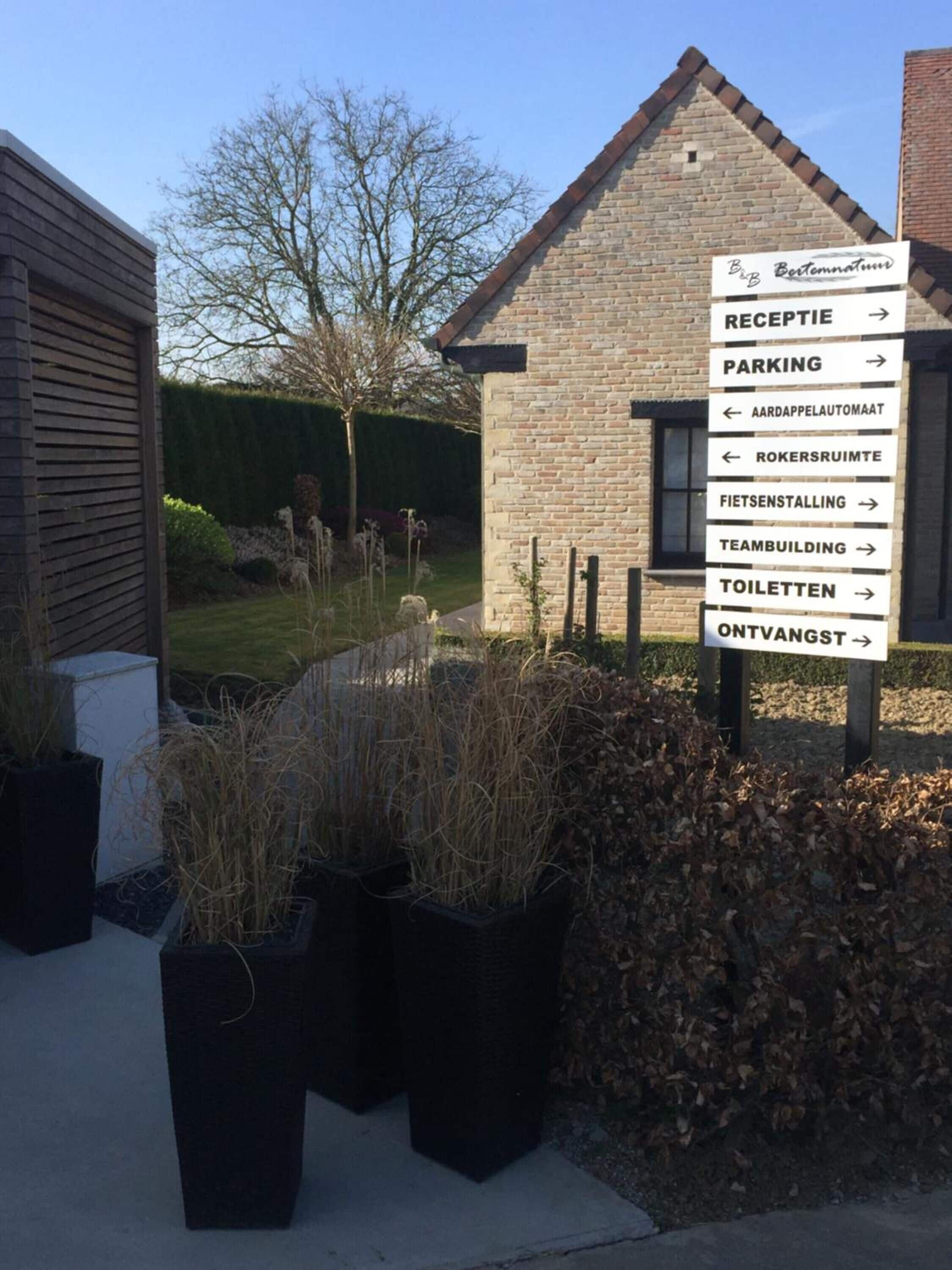 A signpost with directions to various facilities including a reception, parking, and toilets.