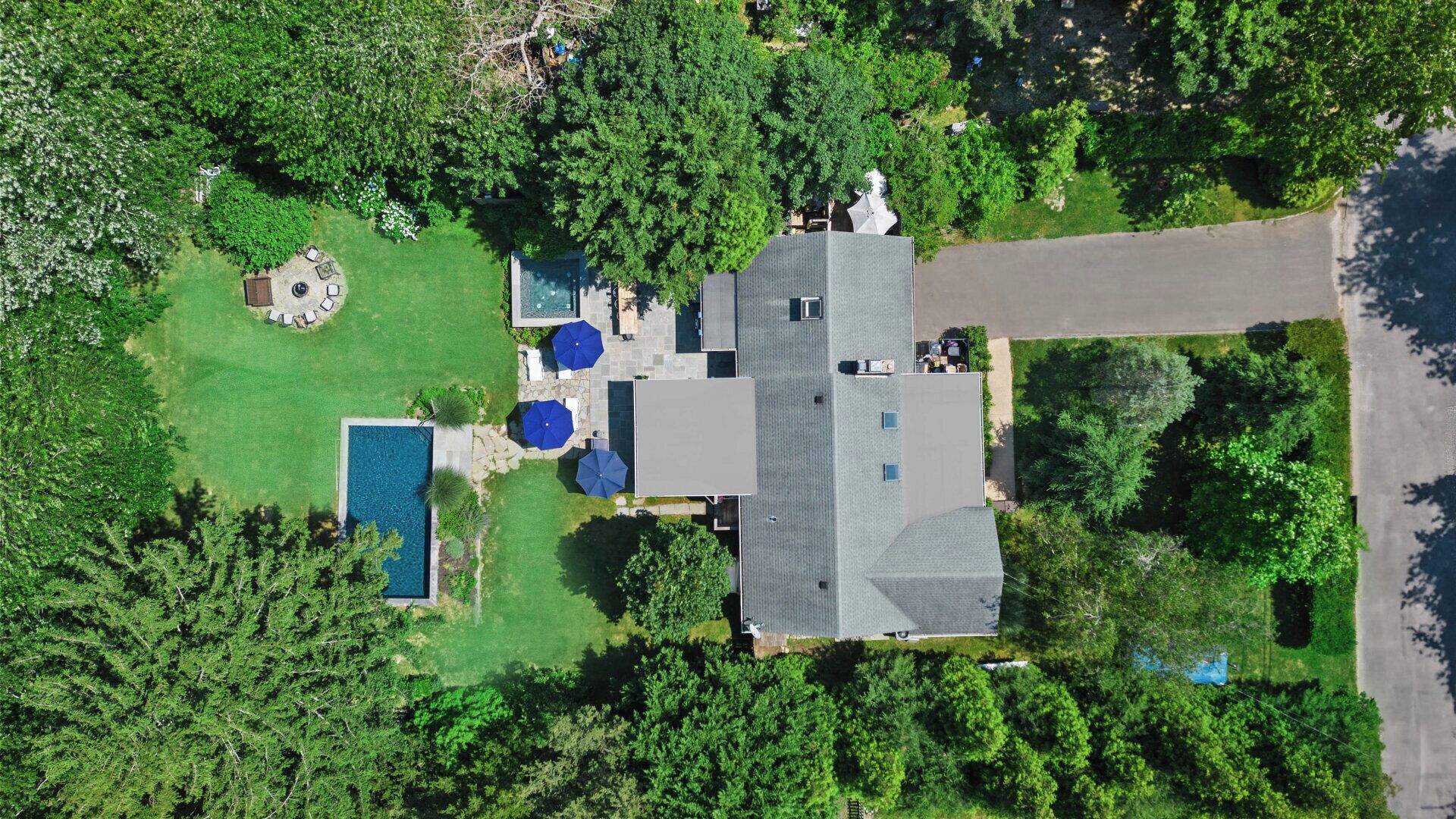Vista aérea de una propiedad residencial con piscina, patio y una casa grande.