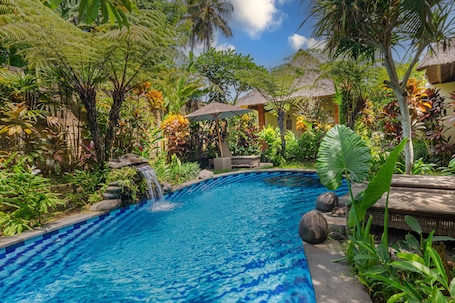 Una piscina al aire libre, camas de piscina gratis, sombrillas