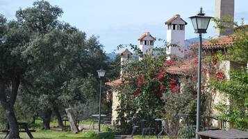 Relax amidst lush greenery and rustic charm, with outdoor dining and seating areas amidst the serene surroundings.
