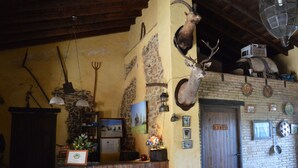 Un interior rústico con mostrador de recepción, vigas de madera y trofeos de animales colgados.