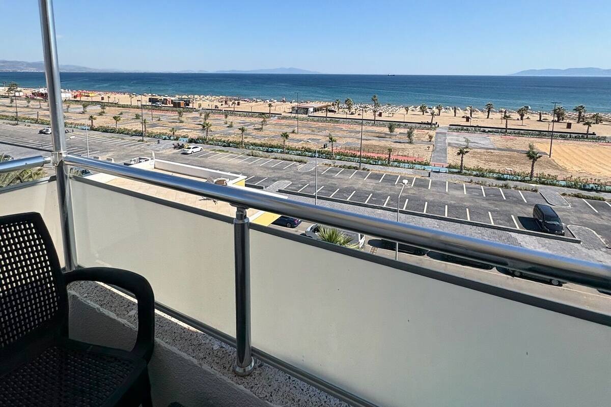 Ein Balkon mit Blick auf Strand und Parkplatz.