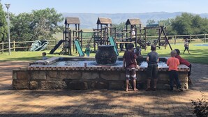 A playground with a water feature and wooden play structures. - Grey Goose Game Lodge (Newcastle)