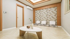 A modern room with a round table, a brick wall, and a door. - Eco Hotel (Mokpo)