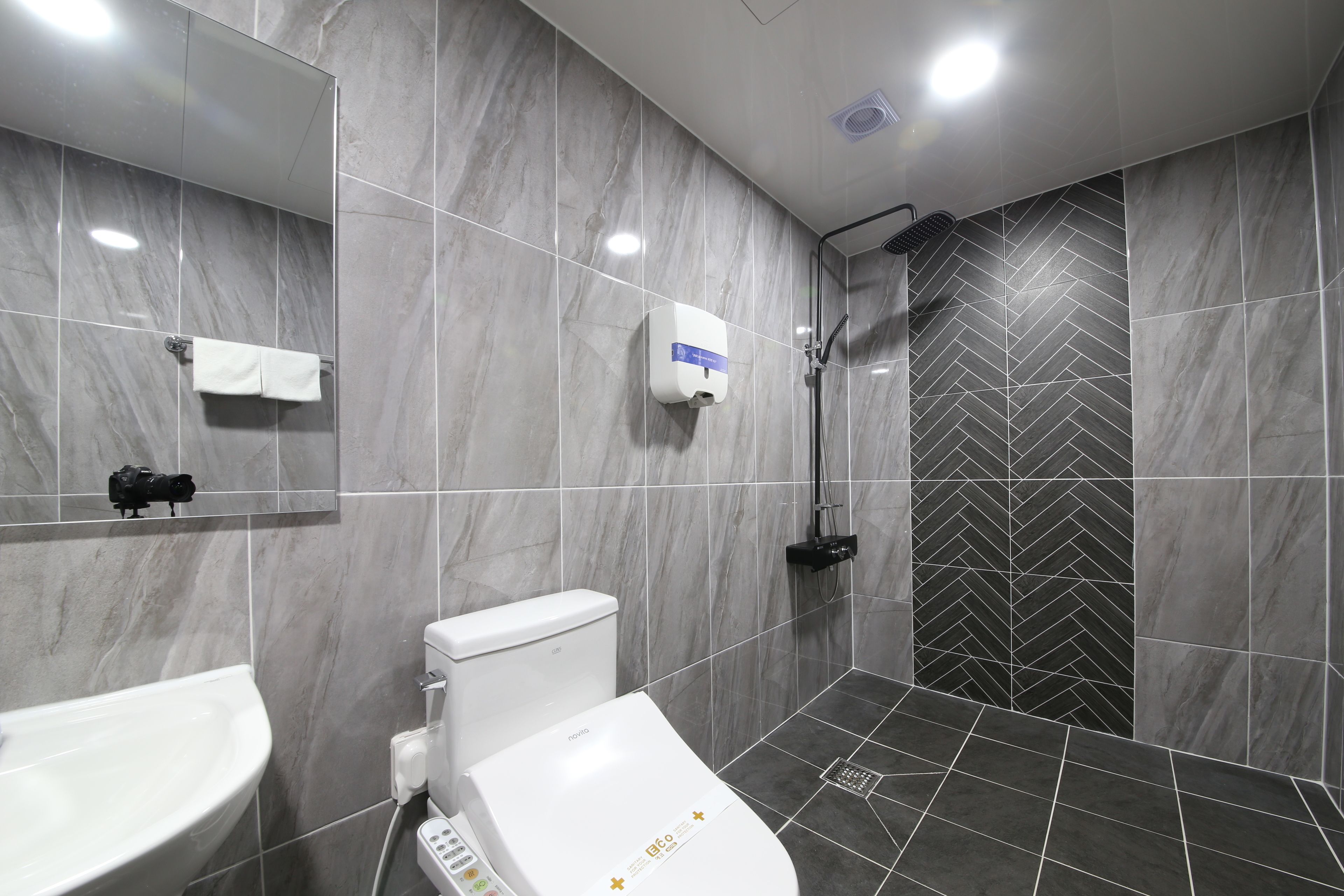 A modern bathroom with a toilet, sink, and shower.
