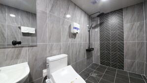 Un baño moderno con inodoro, lavabo y ducha.